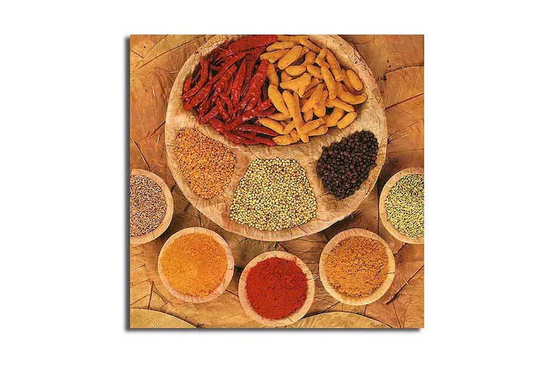 Lerretsbilde 45x45 cm - Fargerik samling av krydder og urter på en rund tallerken, Rød / Gul / Brun