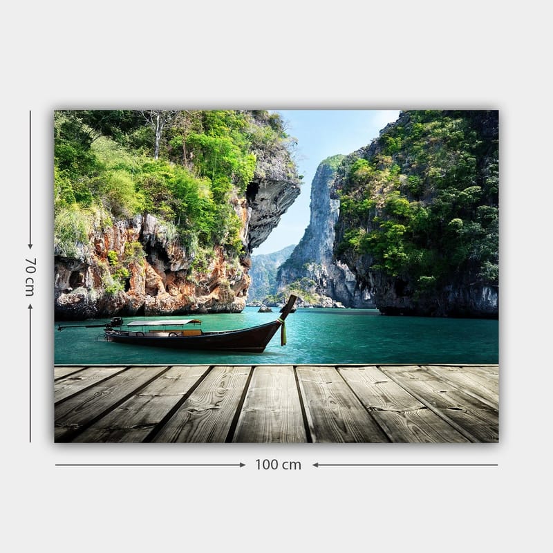 Lerretsbilde 70x100 cm - Båten ligger stille på en steinete strand omgitt av frodige fjell og klart vann - Grønn / Blå / Brun - Innredning - Bilder & kunst - Lerretsbilder