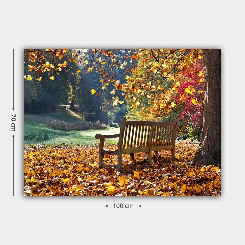 Lerretsbilde 70x100 cm - Benk omgitt av fargerike høstblader i naturskjønne omgivelser - Oransje / Gul / Rød - Innredning - Bilder & kunst - Lerretsbilder