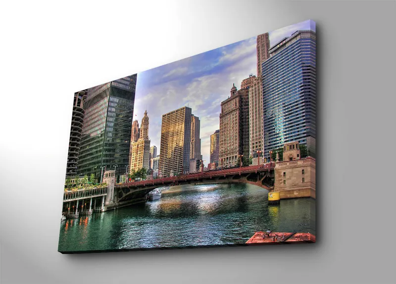 Lerretsbilde 70x100 cm - Bysilhuett med moderne skyskrapere og en bro over en vannvei, Blå / Grønn / Beige