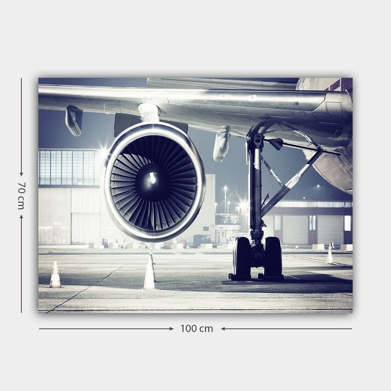 Lerretsbilde 70x100 cm - Detaljert visning av en flymotor og understellet på en flyplass - Grå / Svart / Sølv - Innredning - Bilder & kunst - Lerretsbilder