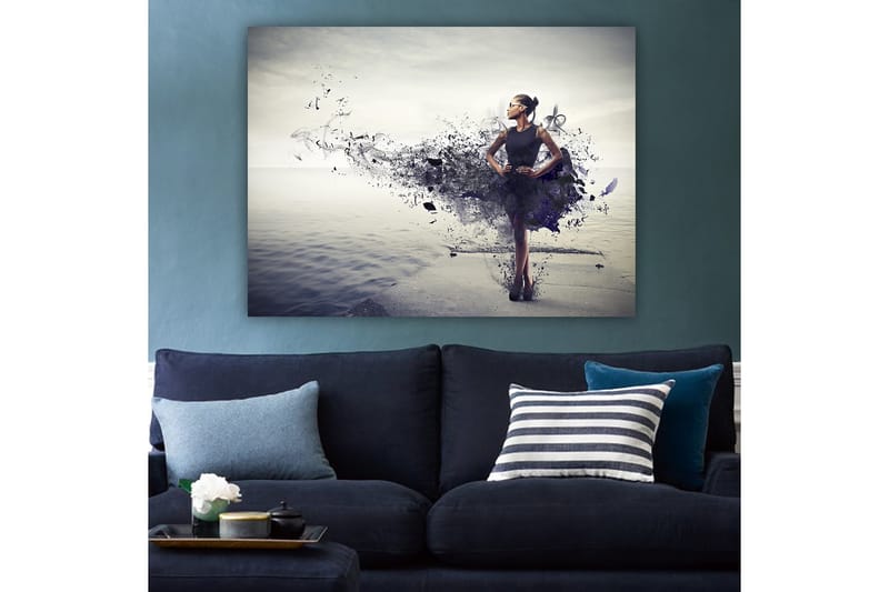 Lerretsbilde 70x100 cm - Elegant kvinne i svart kjole som står på en strand med en abstrakt, fargerik bakgrunn - Svart / Lilla / Grå - Innredning - Bilder & kunst - Lerretsbilder