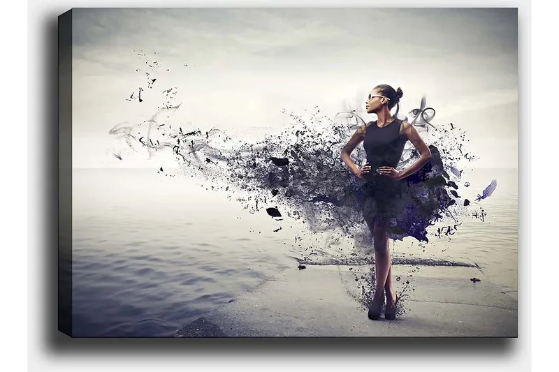 Lerretsbilde 70x100 cm - Elegant kvinne i svart kjole som står på en strand med en abstrakt, fargerik bakgrunn - Svart / Lilla / Grå - Innredning - Bilder & kunst - Lerretsbilder