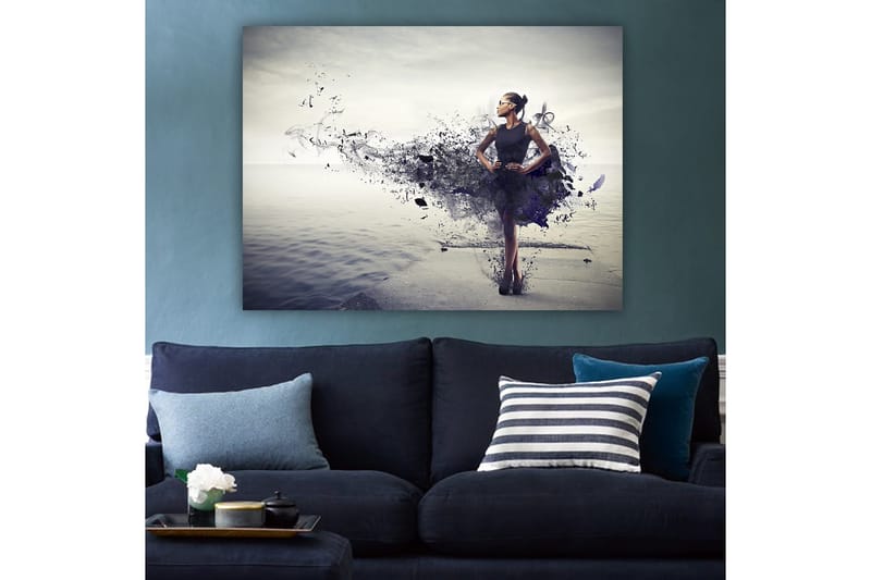 Lerretsbilde 70x100 cm - Elegant kvinne i svart kjole som står på en strand med en abstrakt, fargerik bakgrunn - Svart / Lilla / Grå - Innredning - Bilder & kunst - Lerretsbilder