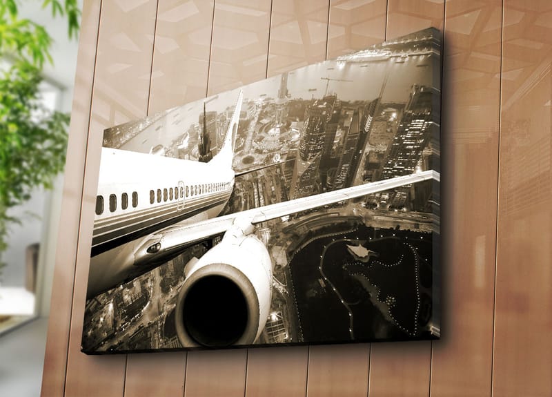 Lerretsbilde 70x100 cm - Et fly som svever over en by i skumringen - Svart / Hvit / Grå - Innredning - Bilder & kunst - Lerretsbilder