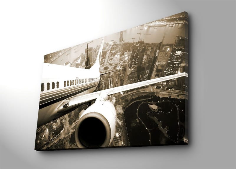 Lerretsbilde 70x100 cm - Et fly som svever over en by i skumringen, Svart / Hvit / Grå