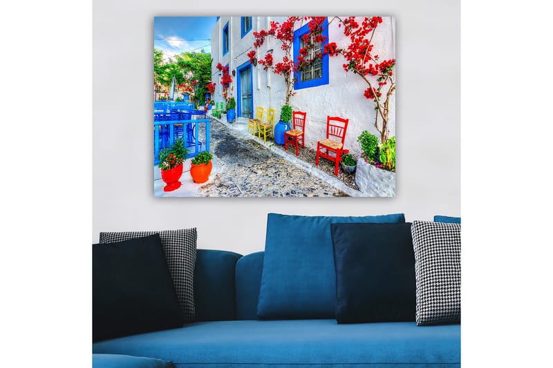 Lerretsbilde 70x100 cm - Fargerik gate med blomster og stoler i forskjellige farger som skaper en livlig atmosfære - Blå / Rød / Grønn - Innredning - Bilder & kunst - Lerretsbilder