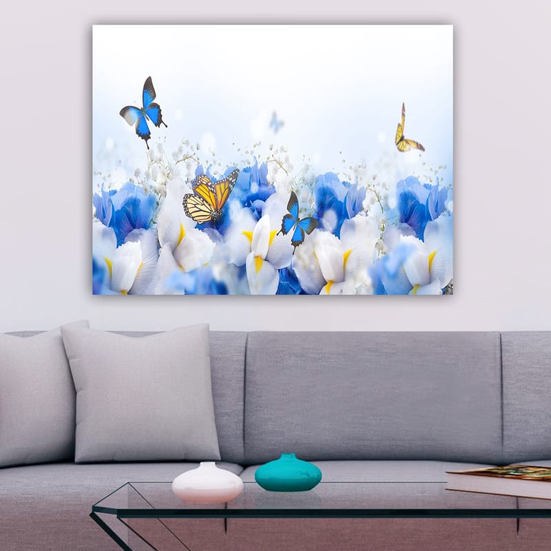 Lerretsbilde 70x100 cm - Fargerik komposisjon av sommerfugler som svever over hvite og blå blomster - Blå / Hvit / Gul - Innredning - Bilder & kunst - Lerretsbilder