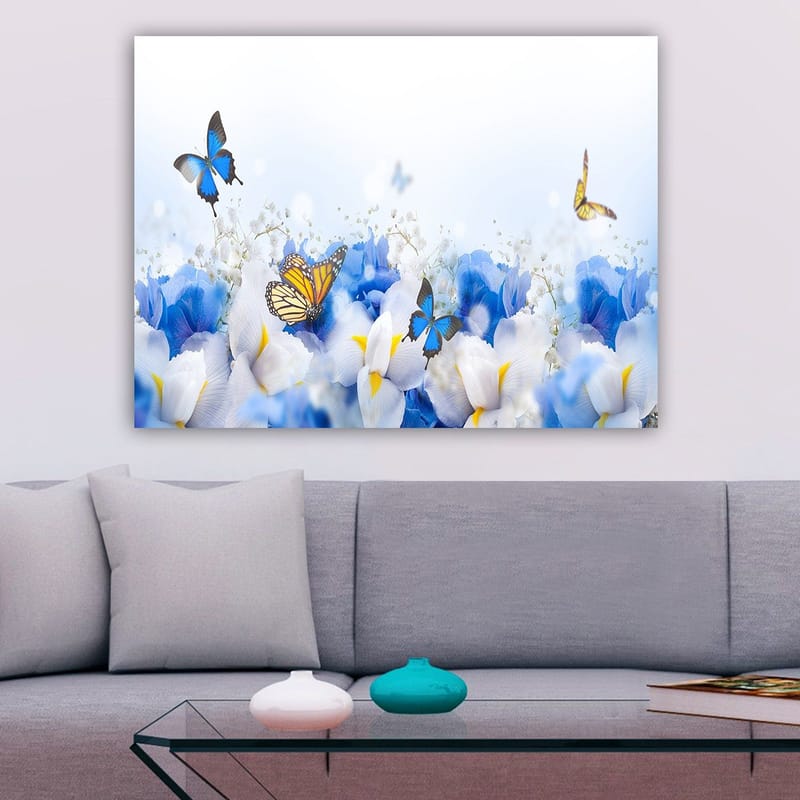 Lerretsbilde 70x100 cm - Fargerik komposisjon av sommerfugler som svever over hvite og blå blomster - Blå / Hvit / Gul - Innredning - Bilder & kunst - Lerretsbilder