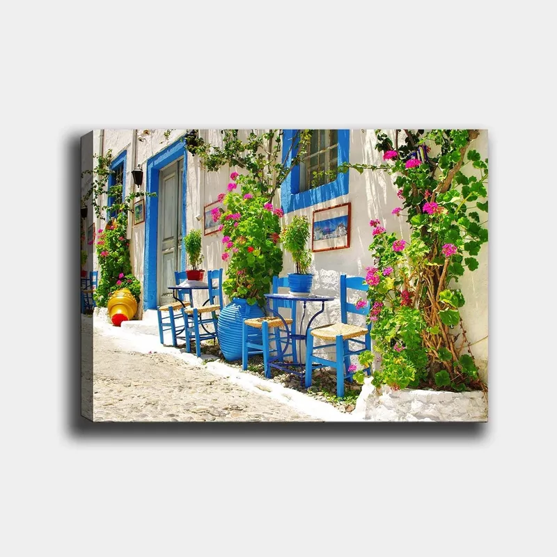 Lerretsbilde 70x100 cm - Fargerik og livlig gate med blå stoler og blomsterpotter i middelhavsmiljø - Blå / Grønn / Rosa - Innredning - Bilder & kunst - Lerretsbilder