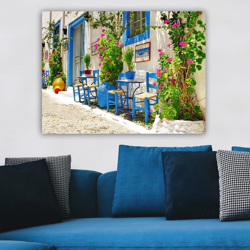 Lerretsbilde 70x100 cm - Fargerik og livlig gate med blå stoler og blomsterpotter i middelhavsmiljø - Blå / Grønn / Rosa - Innredning - Bilder & kunst - Lerretsbilder