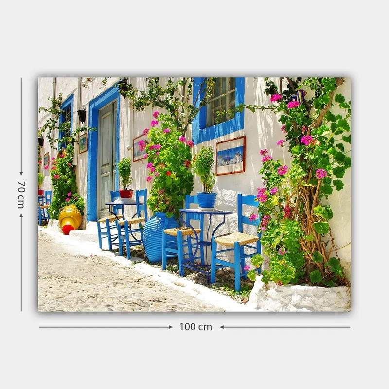 Lerretsbilde 70x100 cm - Fargerik og livlig gate med blå stoler og blomsterpotter i middelhavsmiljø - Blå / Grønn / Rosa - Innredning - Bilder & kunst - Lerretsbilder