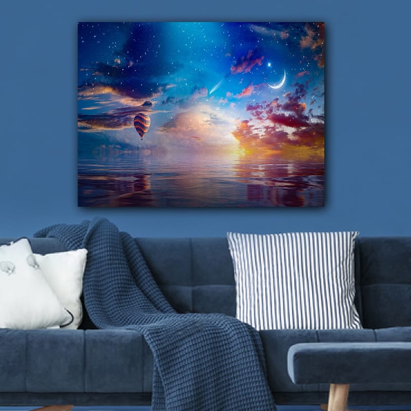Lerretsbilde 70x100 cm - Fargerik varmluftsballong svever over en speillignende overflate under en stjernehimmel med dramatiske skyer og en måne - Blå / Oransje / Rød - Innredning - Bilder & kunst - Lerretsbilder