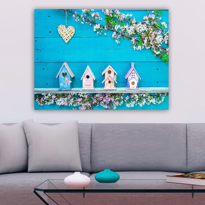 Lerretsbilde 70x100 cm - Fargerike fuglehus på blå bakgrunn med blomster som dekorasjon, Blå / Rosa / Hvit