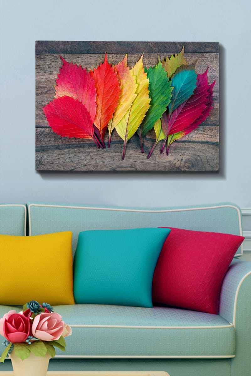 Lerretsbilde 70x100 cm - Fargerike høstblader i forskjellige nyanser som ligger på en treflate - Rød / Grønn / Gul - Innredning - Bilder & kunst - Lerretsbilder