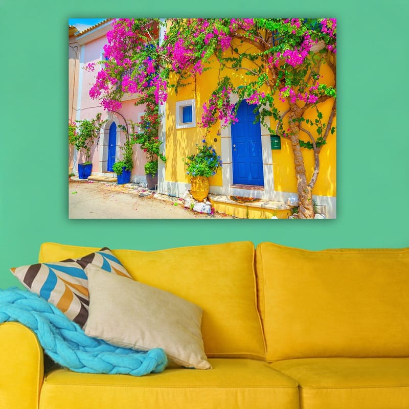 Lerretsbilde 70x100 cm - Fargerike hus med bougainvillea som blomstrer i en travel gate - Blå / Gul / Rosa - Innredning - Bilder & kunst - Lerretsbilder