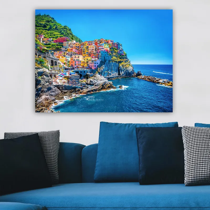 Lerretsbilde 70x100 cm - Fargerike hus som klatrer opp en klippe ved havet - Blå / Gul / Rosa - Innredning - Bilder & kunst - Lerretsbilder