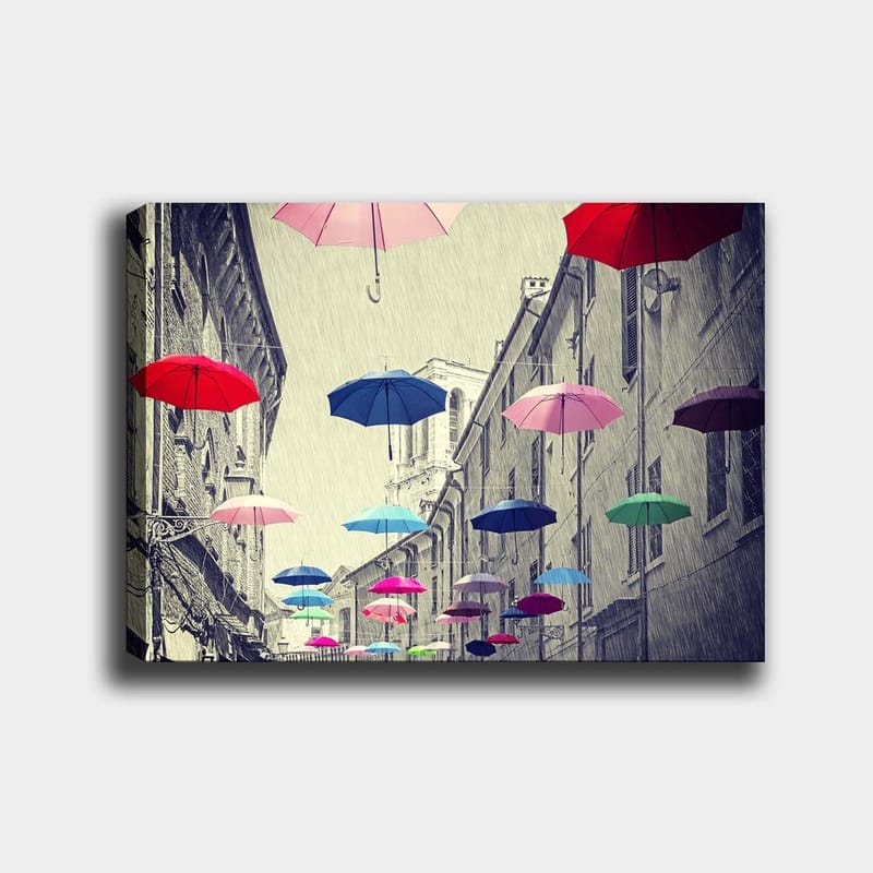 Lerretsbilde 70x100 cm - Fargerike paraplyer svever over en grå bygate, Rød / Blå / Rosa