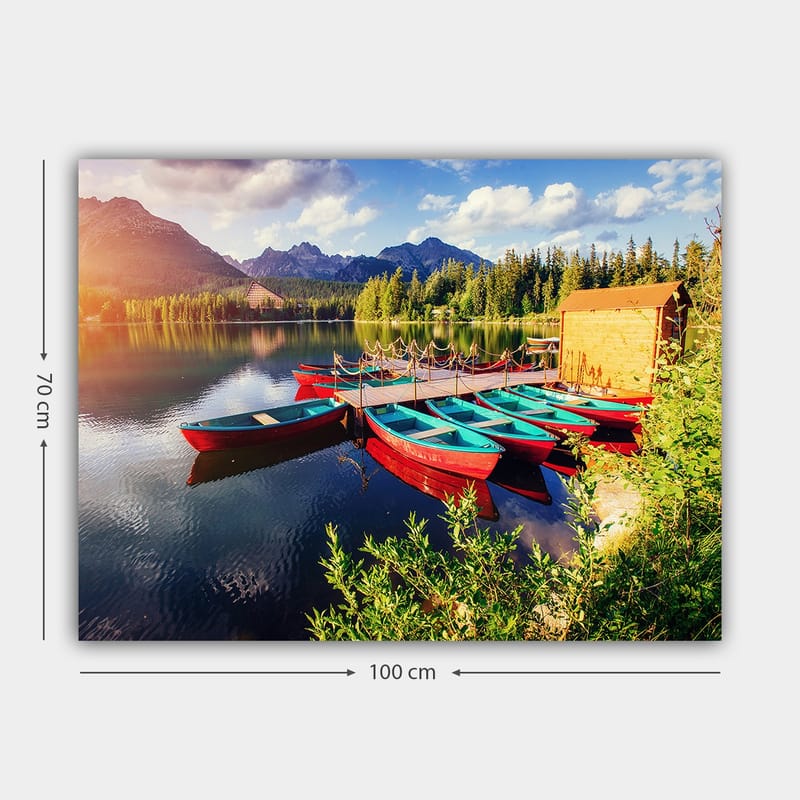 Lerretsbilde 70x100 cm - Flere fargerike båter ligger på en speilblank innsjø omgitt av frodige trær og fjell - Rød / Turkis / Grønn - Innredning - Bilder & kunst - Lerretsbilder