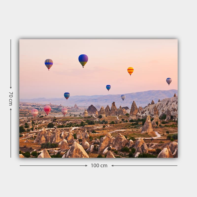 Lerretsbilde 70x100 cm - Flere fargerike varmluftsballonger svever over et dramatisk landskap med unike fjellformasjoner - Blå / Rød / Oransje - Innredning - Bilder & kunst - Lerretsbilder