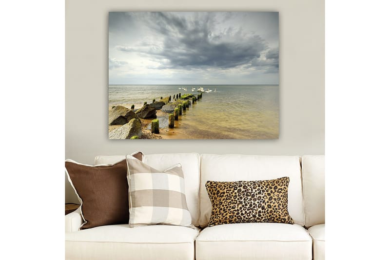 Lerretsbilde 70x100 cm - Fredelig innsjø med svaner som svømmer ved en brygge omgitt av steiner - Grå / Grønn / Blå - Innredning - Bilder & kunst - Lerretsbilder