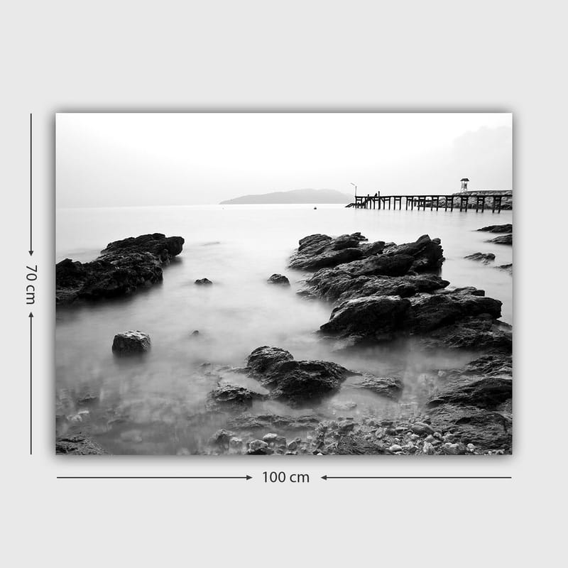 Lerretsbilde 70x100 cm - Fredelig kystlandskap med klipper og en brygge i det fjerne - Svart / Hvit / Grå - Innredning - Bilder & kunst - Lerretsbilder