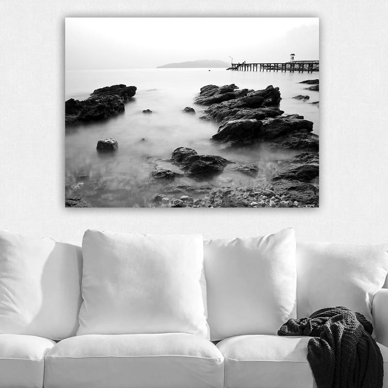 Lerretsbilde 70x100 cm - Fredelig kystlandskap med klipper og en brygge i det fjerne - Svart / Hvit / Grå - Innredning - Bilder & kunst - Lerretsbilder