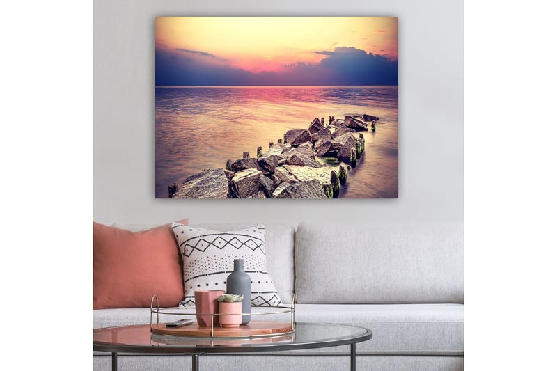 Lerretsbilde 70x100 cm - Fredelig utsikt over en steinete kystlinje ved solnedgang - Grå / Lys blå / Rosa - Innredning - Bilder & kunst - Lerretsbilder