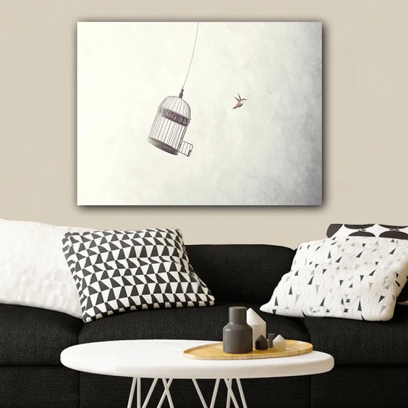 Lerretsbilde 70x100 cm - Fuglebur hengende i luften med en fugl som flyr i nærheten, Grå / Svart / Hvit