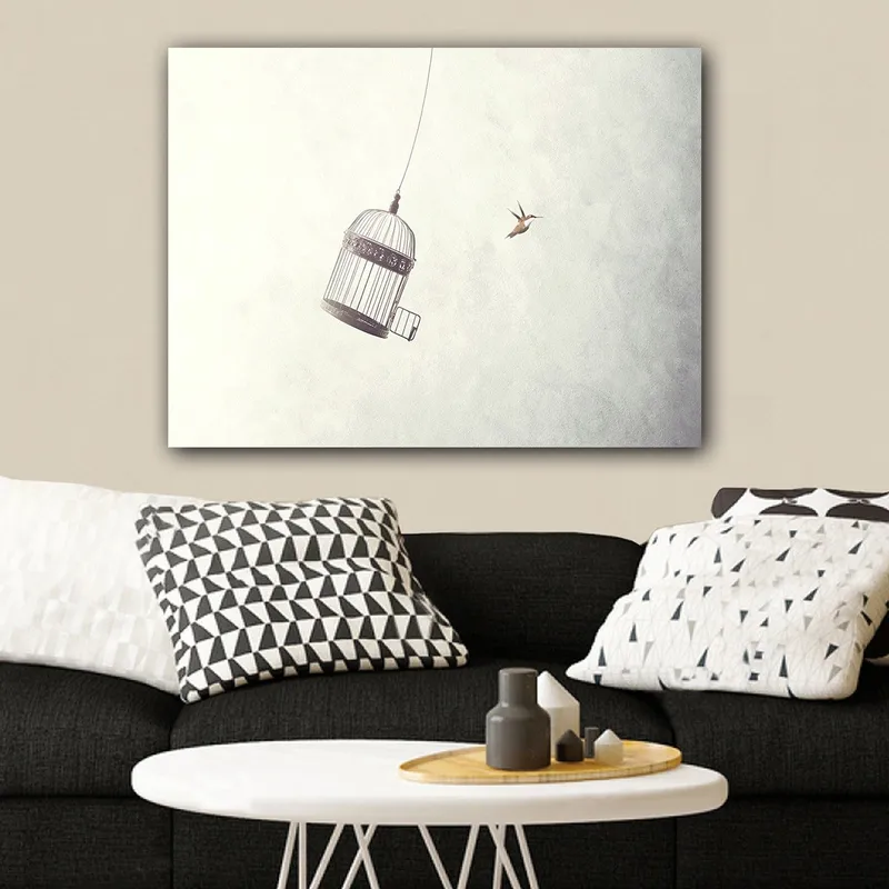 Lerretsbilde 70x100 cm - Fuglebur hengende i luften med en fugl som flyr i nærheten, Grå / Svart / Hvit