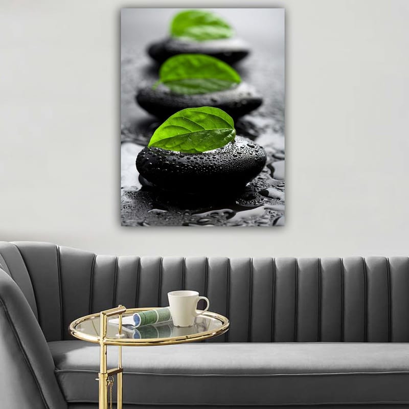 Lerretsbilde 70x100 cm - Harmonisk komposisjon av svarte steiner med grønne blader som symboliserer ro og balanse, Svart / Grønn