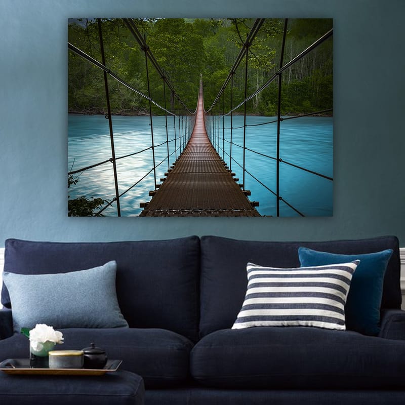 Lerretsbilde 70x100 cm - Hengebro som går over en rolig, blå elv omgitt av frodige trær - Mørk brun / Turkis / Grønn - Innredning - Bilder & kunst - Lerretsbilder