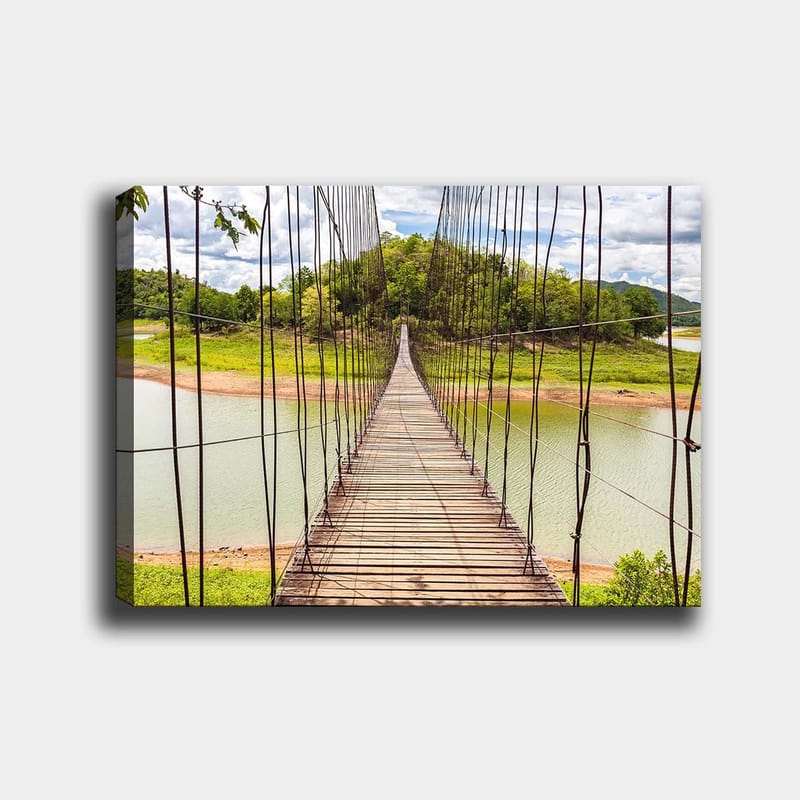 Lerretsbilde 70x100 cm - Hengebro som går over en rolig innsjø, omgitt av frodig grøntområde, Grønn / Brun / Blå