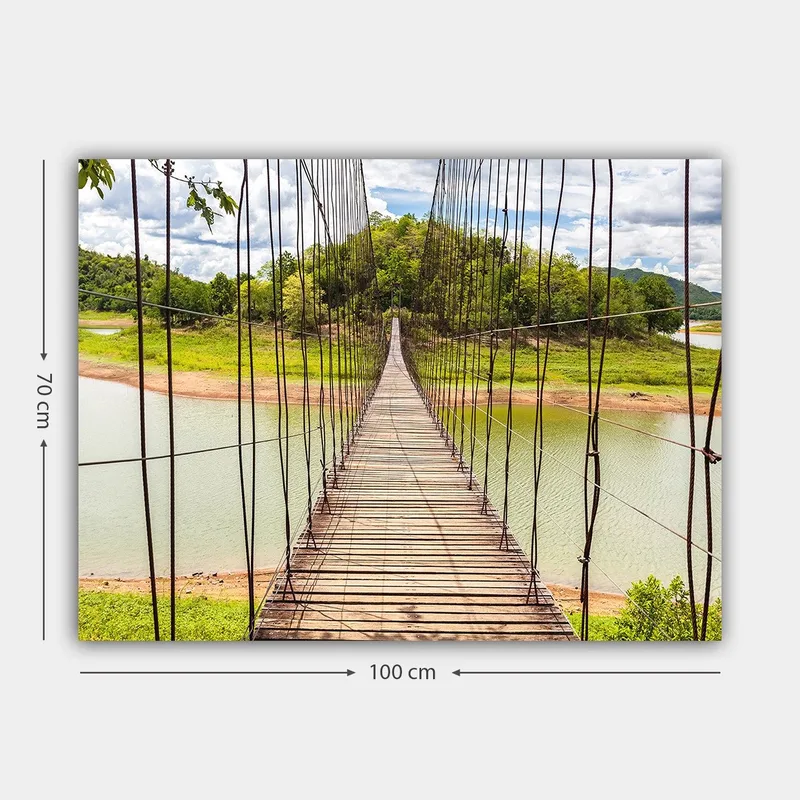 Lerretsbilde 70x100 cm - Hengebro som går over en rolig innsjø, omgitt av frodig grøntområde - Grønn / Brun / Blå - Innredning - Bilder & kunst - Lerretsbilder