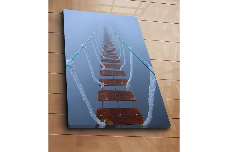 Lerretsbilde 70x100 cm - Hengebro som strekker seg gjennom tåken og skaper en mystisk og fjern følelse - Mørk brun / Hvit / Lys blå - Innredning - Bilder & kunst - Lerretsbilder