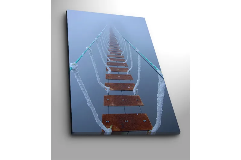 Lerretsbilde 70x100 cm - Hengebro som strekker seg gjennom tåken og skaper en mystisk og fjern følelse - Mørk brun / Hvit / Lys blå - Innredning - Bilder & kunst - Lerretsbilder