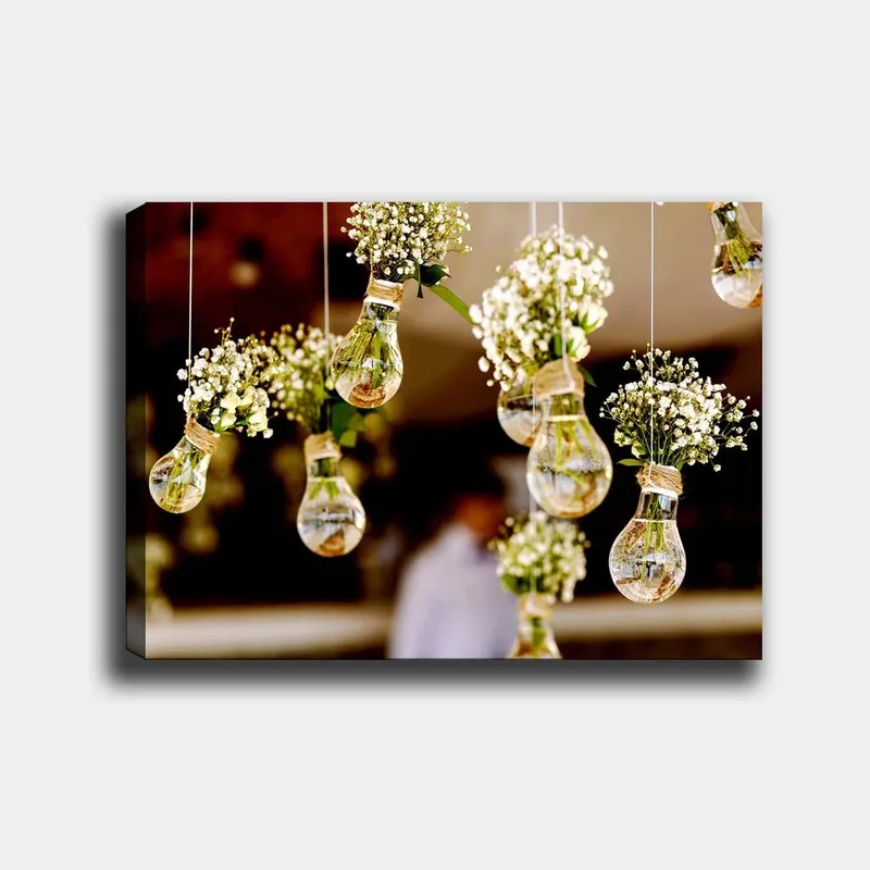 Lerretsbilde 70x100 cm - Hengende lyspærer med blomster som skaper en romantisk og kreativ atmosfære, Grønn / Hvit / Brun