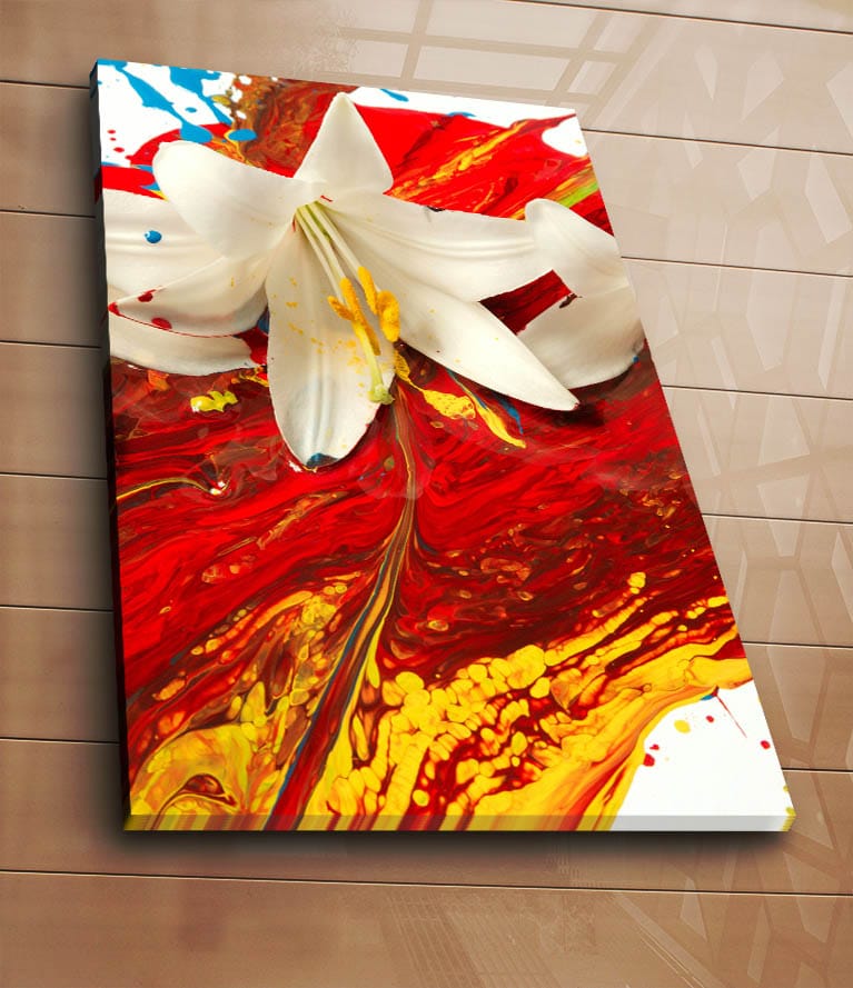 Lerretsbilde 70x100 cm - Hvit lilje som står frem mot en bakgrunn av intense røde og gule farger - Rød / Gul / Hvit - Innredning - Bilder & kunst - Lerretsbilder