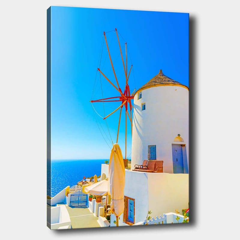 Lerretsbilde 70x100 cm - Hvit vindmølle med rød rotor på en klippe ved havet, omgitt av klar blå himmel og hav, Hvit / Rød / Blå
