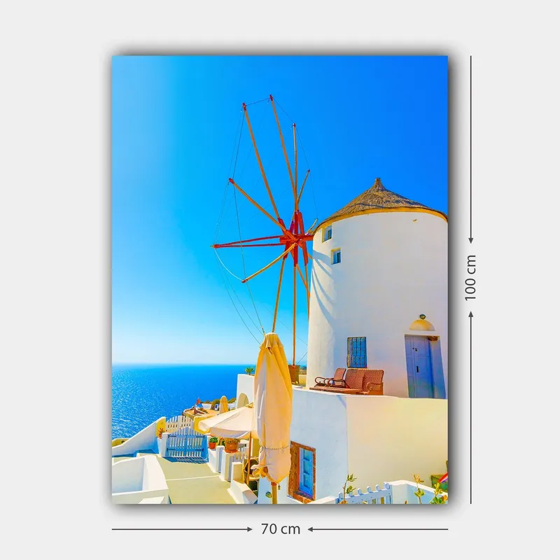 Lerretsbilde 70x100 cm - Hvit vindmølle med rød rotor på en klippe ved havet, omgitt av klar blå himmel og hav - Hvit / Rød / Blå - Innredning - Bilder & kunst - Lerretsbilder