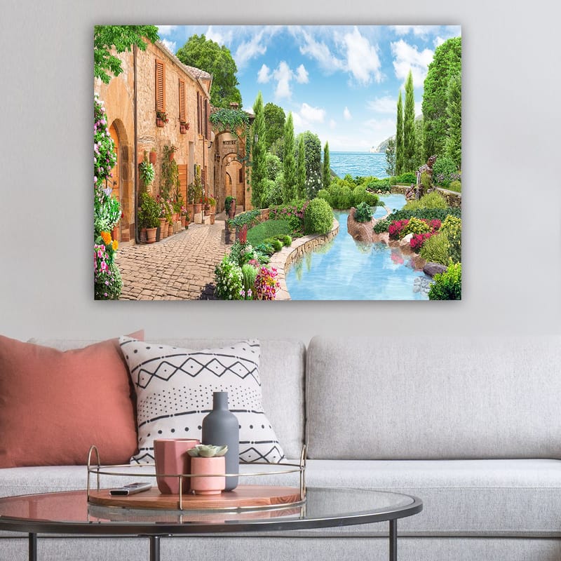 Lerretsbilde 70x100 cm - Idyllisk landsby med blomster, trær og en glitrende innsjø i bakgrunnen - Grønn / Blå / Terrakotta - Innredning - Bilder & kunst - Lerretsbilder