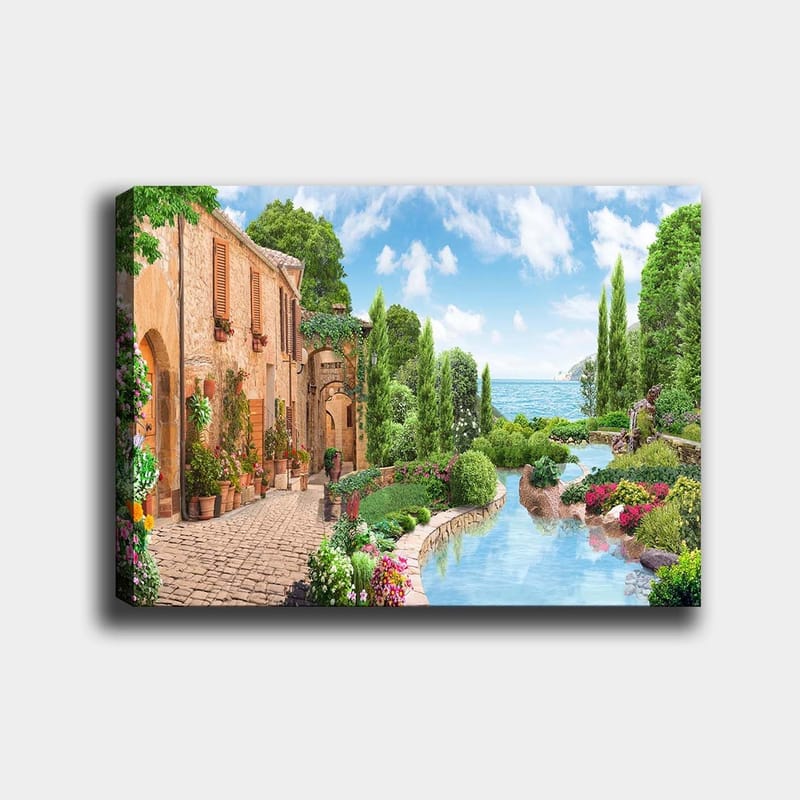 Lerretsbilde 70x100 cm - Idyllisk landsby med blomster, trær og en glitrende innsjø i bakgrunnen, Grønn / Blå / Terrakotta