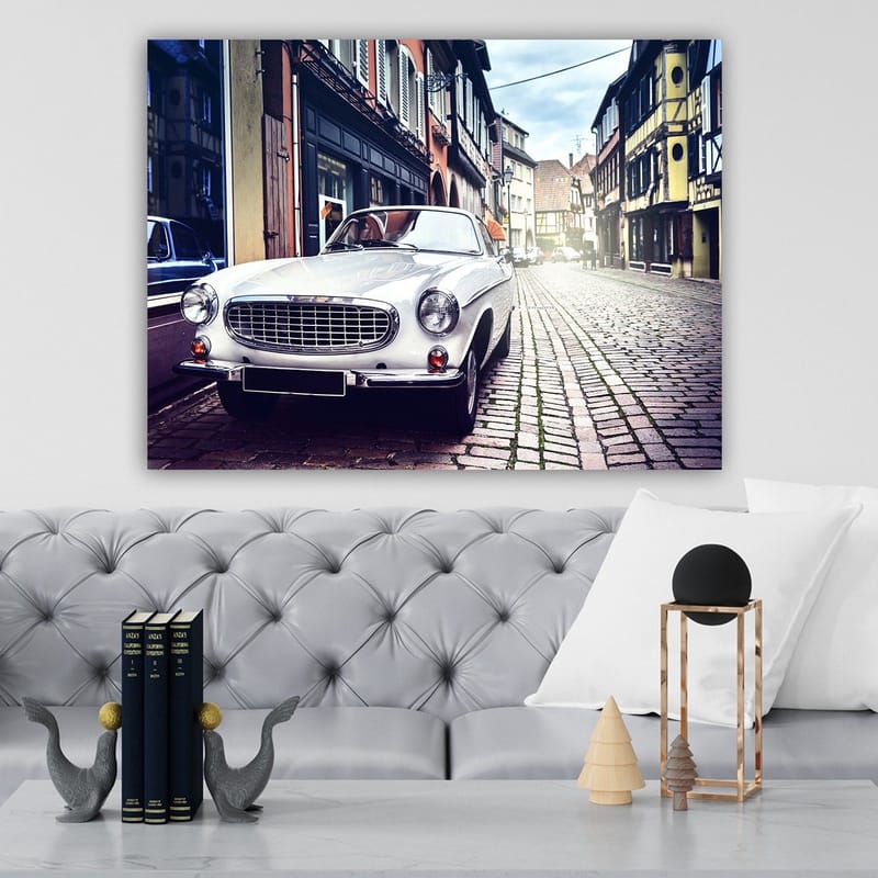 Lerretsbilde 70x100 cm - Klassisk hvit bil parkert i en sjarmerende, gammeldags gate med historiske bygninger - Hvit / Svart / Grå - Innredning - Bilder & kunst - Lerretsbilder