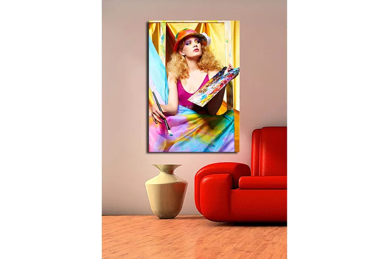 Lerretsbilde 70x100 cm - Kreativ kvinne som maler med en palett i hånden, omgitt av fargerike stoffer - Rosa / Blå / Gul - Innredning - Bilder & kunst - Lerretsbilder