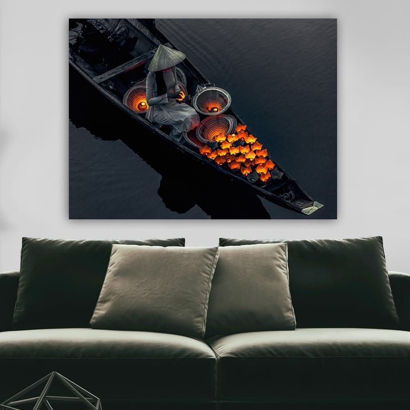 Lerretsbilde 70x100 cm - Kvinne i en båt som omgir seg med knalloransje fisk og tradisjonelle kurver - Oransje / Svart / Grå - Innredning - Bilder & kunst - Lerretsbilder