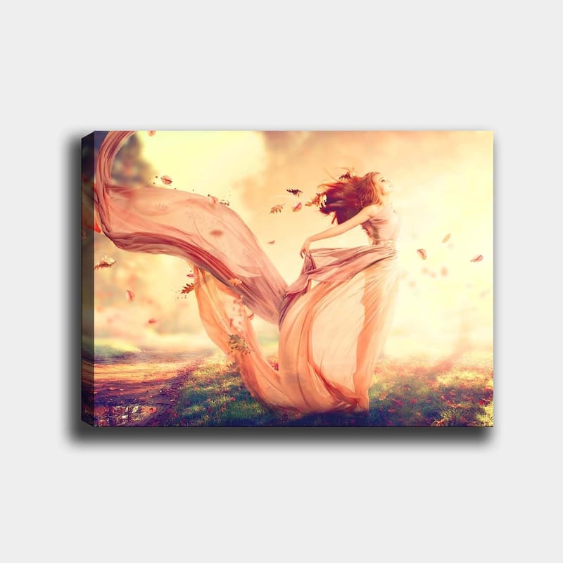 Lerretsbilde 70x100 cm - Kvinne i en flagrende kjole som danser i et drømmeaktig høstlandskap med fallende blader, Lys rosa / Beige / Myk gul
