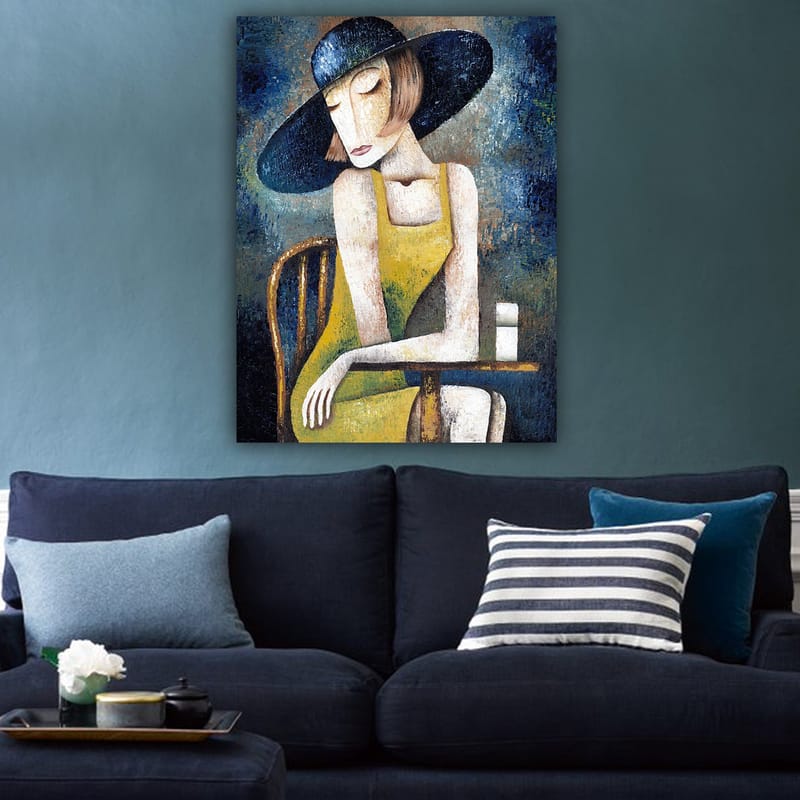 Lerretsbilde 70x100 cm - Kvinne i gul kjole sitter ved et bord med en hvit kopp, iført en stor svart hatt - Gul / Svart / Blågrønn - Innredning - Bilder & kunst - Lerretsbilder