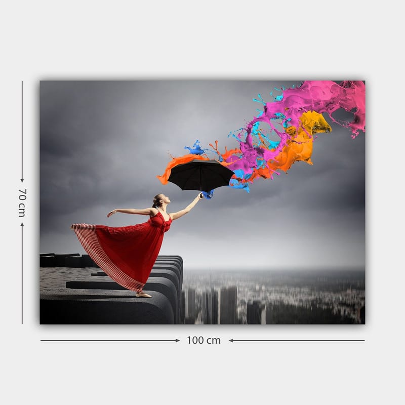 Lerretsbilde 70x100 cm - Kvinne i rød kjole står på en kant og holder en paraply, mens fargerike malingsstråler spruter ut fra den - Rød / Svart / Oransje - Innredning - Bilder & kunst - Lerretsbilder