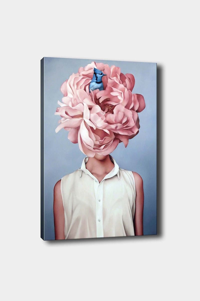 Lerretsbilde 70x100 cm - Kvinne med et stort rosa blomsterhodeplagg og en blå fugl som sitter blant blomstene, Rosa / Blå / Beige