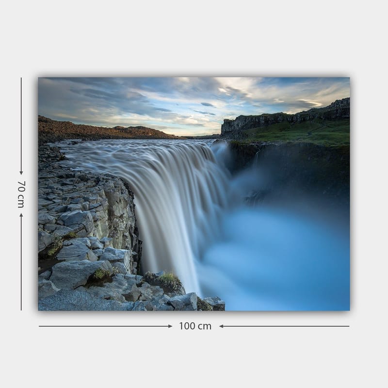 Lerretsbilde 70x100 cm - Majestetisk foss som renner over steiner i naturskjønne omgivelser - Blå / Grå / Hvit - Innredning - Bilder & kunst - Lerretsbilder